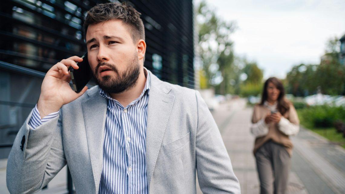 Businessman receiving bad news during phone call outdoors